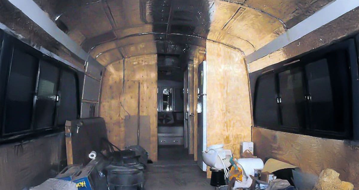 An interior shot showing the plywood walls used to separate to rooms. The completed bedrooms are shown in the back.