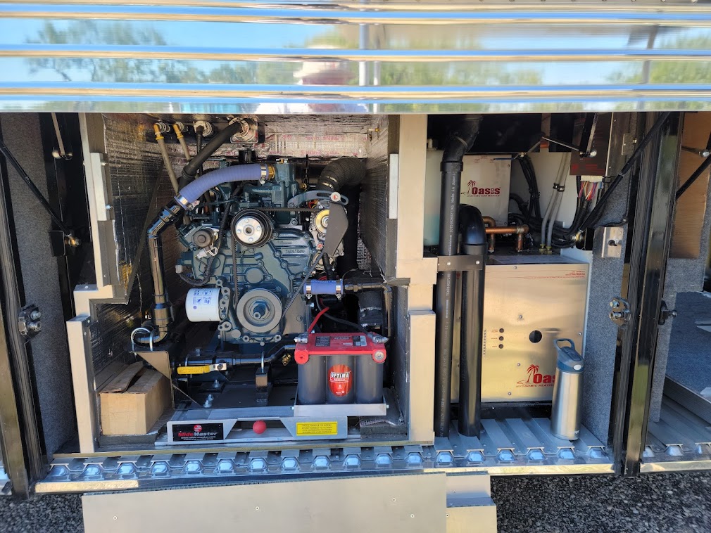 House batteries, an inverter, freshwater tanks, a generator on a slide-out tray, and an Oasis heating system.