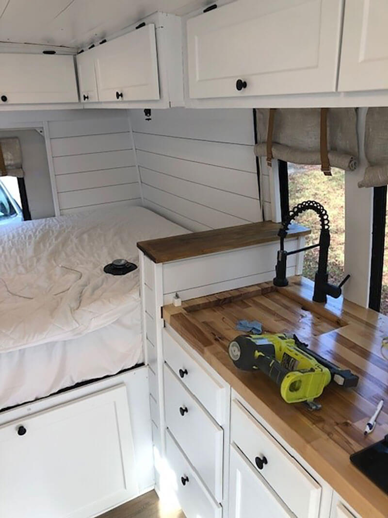 All of the cabinets are painted, the bed is in place and the kitchen is almost completed!
