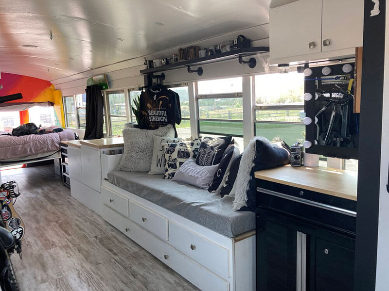 The bench couch transforms into a full-size bed. There is storage underneath for clothing as well as photo backdrops. Husky toolboxes are used for a vanity, built by Dan Messick.