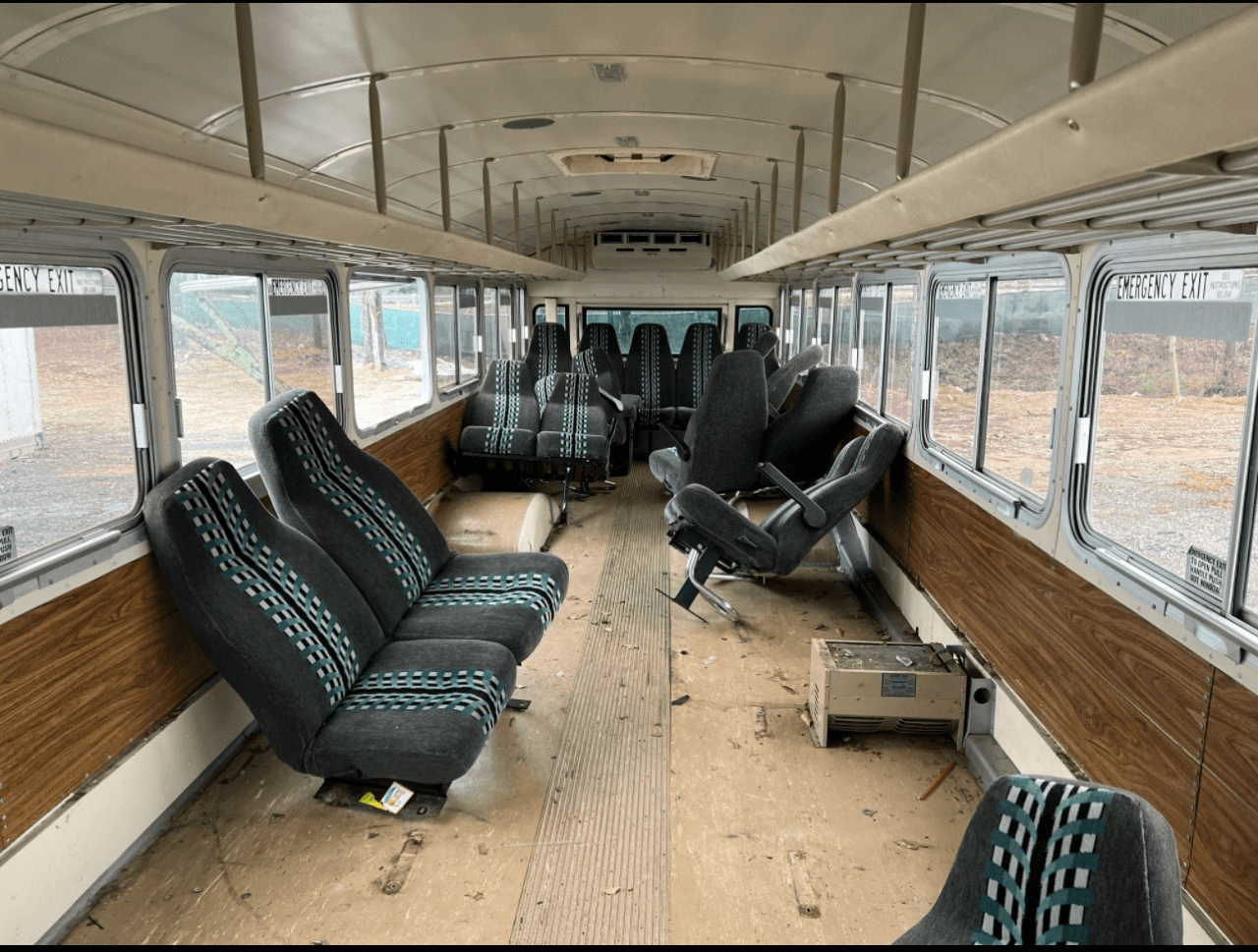 Bus racks and seats inside of the bus. Time to start a bus conversion!