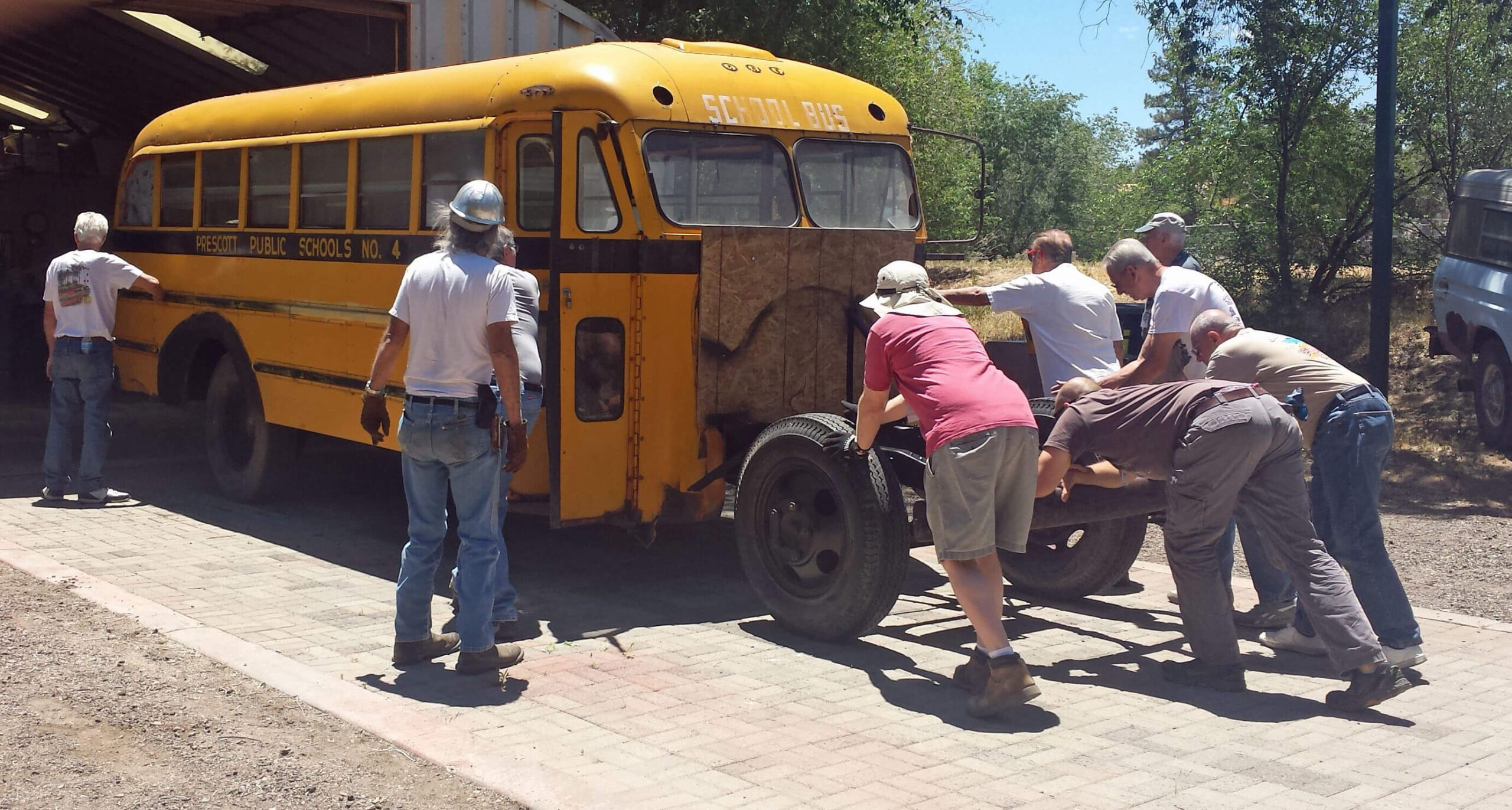 Tuesday work crew pushing the bus into the clubhouse for more assembly.