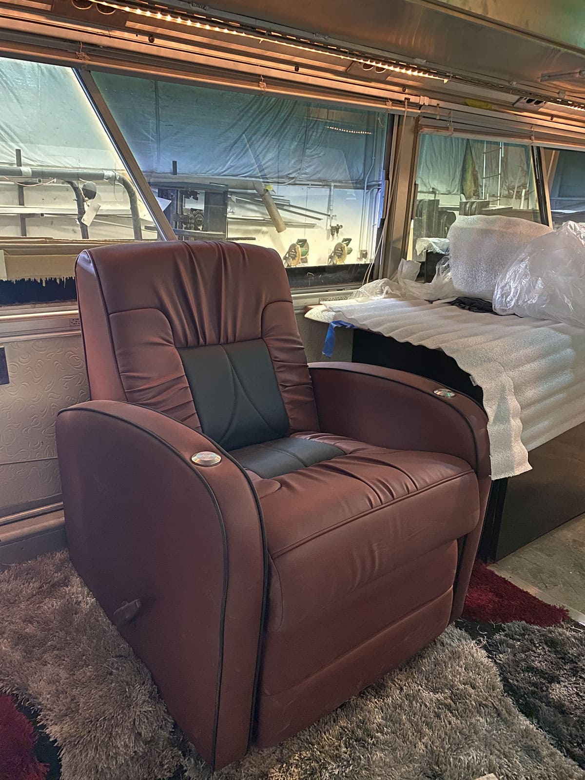 The swiveling DeLeon recliner shows custom black inlay inserts with mount points for armchair trays. Above, you can see a glimpse of the LED rope lighting.